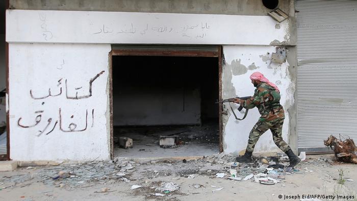 A Syrian soldier in front of building JOSEPH EID/AFP/Getty Images) 
