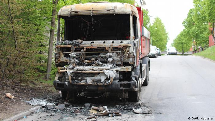The burned front end of a large van sits on an empty, leafy street in Sweden
(Photo: DW/Randi Häussler)