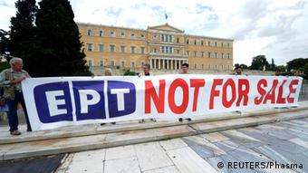 Protesters hold a banner in front of the parliament in Athens June 14, 2013. Greek Prime Minister Antonis Samaras moved to defuse a political crisis over the government's abrupt closure of state broadcaster ERT that prompted a nationwide strike on Thursday and brought thousands into the streets in protest. REUTERS/Phasma/Giorgos Nikolaidis (GREECE - Tags: CIVIL UNREST POLITICS BUSINESS EMPLOYMENT MEDIA) GREECE OUT. NO COMMERCIAL OR EDITORIAL SALES IN GREECE