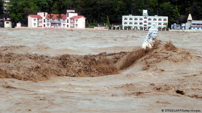 Fast moving water flows over a Hindu statue during a heavy monsoon rain in Rishikesh town in the Indian state of Uttrakhand on June 17, 2013. Heavy rains lashed parts of north India Monday, resulting in the deaths of at least 18 people, as the annual monsoon covered the country nearly two weeks ahead of schedule, officials said. More than a dozen people lost their lives due to record downpours in Uttarakhand state, situated in the foothills of the Himalayas, a local official said. AFP PHOTO/ STR (Photo credit should read STRDEL/AFP/Getty Images) 