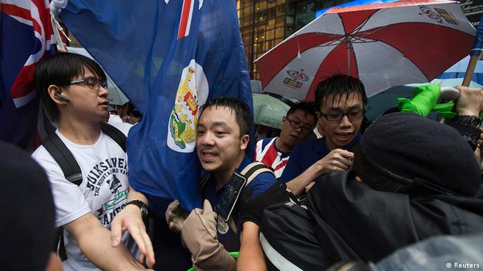 Pro-democracy protesters, with Hong Kong colonial flags, clash with police during a protest to demand universal suffrage and urge Hong Kong's Chief Executive Leung Chun-ying to step down in Hong Kong July 1, 2013. Monday marked the 16th anniversary of the territory's handover to China from Britain. REUTERS/Tyrone Siu (CHINA - Tags: POLITICS CIVIL UNREST ANNIVERSARY)