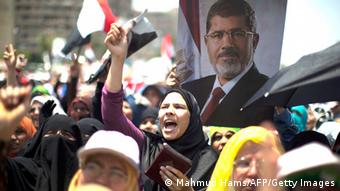 Egyptian supporters of the Muslim Brotherhood shout slogans during a rally in support with deposed president Mohamed Morsi (featured on the poster) on July 6, 2013 outside Cairo's Rabaa al-Adawiya mosque. Egypt's Islamists vowed further protests today to demand the army restore the country's first democratically elected leader, after a day of clashes which saw 26 people killed across the country. AFP PHOTO/MAHMUD HAMS (Photo credit should read MAHMUD HAMS/AFP/Getty Images) 