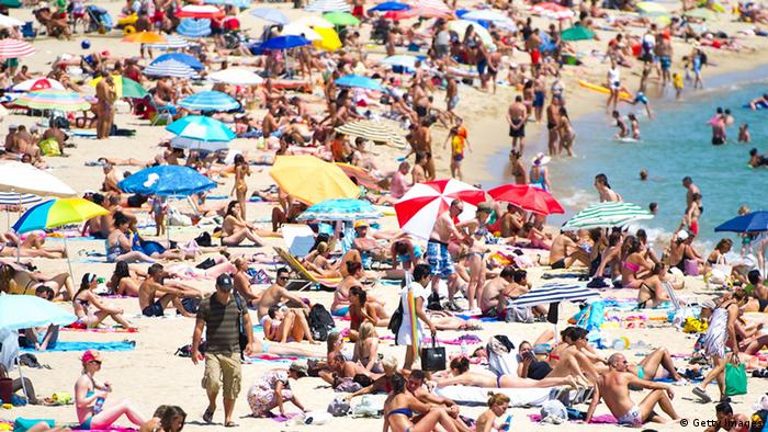 BARCELONA, SPAIN - AUGUST 04: People sunbathe at the La Mar Bella Beach on August 4, 2012 in Barcelona, Spain. Tourism is the largest contributor to the welfare of Spain's economy. Catalonia is the main destination for tourists, with 6.3 million visitors for the first half of the year, 12.3% more than in 2011. (Photo by David Ramos/Getty Images)