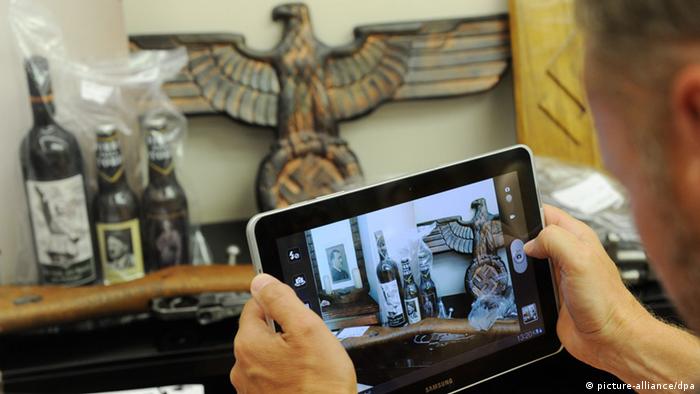 Un periodista registra con su tableta objetos confiscados a neonazis en Múnich. 