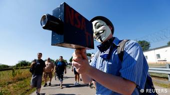 A protester wearing a Guy Fawkes mask holds a paper-made mock TV camera during a demonstration against the National Security Agency (NSA) and in support of U.S. whistleblower Edward Snowden, outside the Dagger Complex, which is used by the U.S. Army intelligence services, in Griesheim, 20 km (12.4 miles) south of Frankfurt, July 20, 2013. REUTERS/ Kai Pfaffenbach (GERMANY - Tags: POLITICS CIVIL UNREST CRIME LAW TPX IMAGES OF THE DAY)