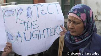 A woman holds a placard: 'Protect our daughters' (Photo: Farooq Khan)
