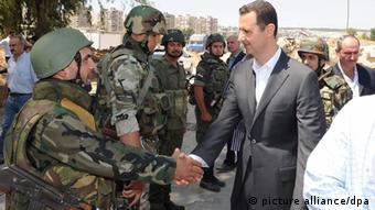 Rais Bashar al-Assad akisalimiana na wanajeshi wake mjini Damascus hivi karibuni.
