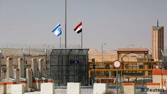 An Israeli flag (L) flutters next to an Egyptian one at the Nitzana crossing, along Israel's border with Egypt's Sinai desert. REUTERS/Ronen Zvulun (ISRAEL - Tags: POLITICS)