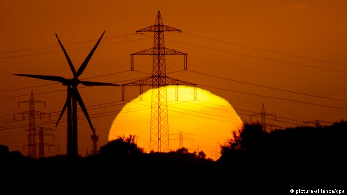 A sun setting behind wind turbines and electrcity masts
(photo: Julian Stratenschulte/dpa)