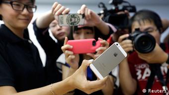 Journalists take photos of a new iPhone 5S during Apple Inc's announcement event in Beijing, September 11, 2013. Apple Inc's millions of Chinese fans will celebrate the near-simultaneous launch of the latest iPhone in China and the United States, but one group will have little to cheer - the smugglers. An early launch of Apple's latest smartphone in China is expected to stifle a thriving grey market worth billions of dollars a year built around smuggling from Hong Kong, where in the past the U.S. tech giant's gadgets have gone on sale months before they reach official channels in the mainland. REUTERS/Jason Lee (CHINA - Tags: MEDIA BUSINESS SCIENCE TECHNOLOGY)
