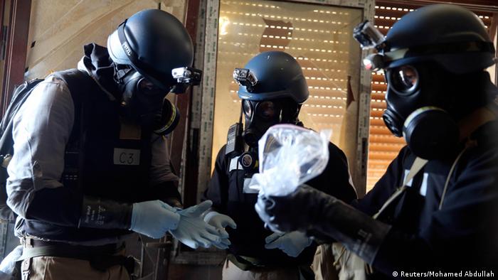 A U.N. chemical weapons expert, wearing a gas mask, holds a plastic bag containing samples from one of the sites of an alleged chemical weapons attack in the Ain Tarma neighbourhood of Damascus in this August 29, 2013 file photo. A report by U.N. chemical weapons experts will likely confirm that poison gas was used in an August 21 attack on Damascus suburbs that killed hundreds of people, U.N. Secretary-General Ban Ki-moon said on September 13, 2013. France's U.N. ambassador, Gerard Araud, told reporters that September 16, 2013 is the tentative date for Ban to present Sellstrom's report to the Security Council and other U.N. member states. REUTERS/Mohamed Abdullah/Files (SYRIA - Tags: POLITICS CIVIL UNREST CONFLICT HEALTH)