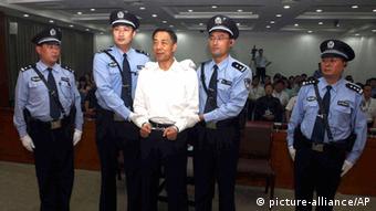 In this photo released by the Jinan Intermediate People's Court, fallen politician Bo Xilai, center, is handcuffed and held by police officers as he stands at the court in Jinan, in eastern China's Shandong province Sunday, Sept. 22, 2013. The Chinese court convicted Bo on charges of taking bribes, embezzlement and abuse of power and sentenced him to life in prison, capping one of the country's most lurid political scandals in decades. (AP Photo/Jinan Intermediate People's Court)   ***FREI FÜR SOCIAL MEDIA***