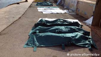 epa03893732 A row of dead bodies are covered with sheets at the port of Lampedusa, Italy, 03 October 2013. According to Italian port authorities, at least 82 bodies have been recovered off the Italian coast after a ship carrying migrants sank near the southern island of Lampedusa. The ship, which was believed to be carrying hundreds of migrants from Somalia and Eritrea, suffered extensive damage as it approached the smaller island of Conigli. EPA/NINO RANDAZZO BEST QUALITY AVAILABLE. +++(c) dpa - Bildfunk+++ 
