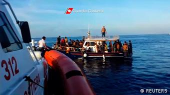 A still image taken from video released on October 4, 2013 by the Italian Coastguard shows migrants rescued from the water off the southern Italian island of Lampedusa on Thursday October 3, 2013. Italian rescue workers have pulled 111 bodies from the migrant boat that sank off the island of Lampedusa on Thursday and expect to recover more than a hundred more from the submerged wreck, a coastguard official said on Friday. Footage taken October 3, 2013. REUTERS/Italian Coast Guard/Handout via Reuters (ITALY - Tags: DISASTER) ATTENTION EDITORS - THIS IMAGE WAS PROVIDED BY A THIRD PARTY. FOR EDITORIAL USE ONLY. NOT FOR SALE FOR MARKETING OR ADVERTISING CAMPAIGNS. THIS PICTURE IS DISTRIBUTED EXACTLY AS RECEIVED BY REUTERS, AS A SERVICE TO CLIENTS. MANDATORY CREDIT