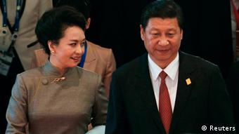 China's President Xi Jinping (C) and his wife Peng Liyuan (L) attend the Asia-Pacific Economic Cooperation (APEC) Summit in Nusa Dua on the Indonesian resort island of Bali October 7, 2013. REUTERS/Beawiharta (INDONESIA - Tags: POLITICS)
