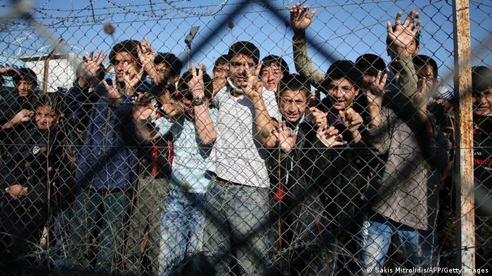 Immigrant minors peer out through the fence of an immigrant detention center in the village of Filakio, on the Greek-Turkish border. (Photo: SAKIS MITROLIDIS/AFP/Getty Images)