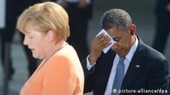 ARCHIV - US-Präsident Barack Obama (r) wischt sich am 19.06.2013 den Schweiß von der Stirn neben Kanzlerin Angela Merkel auf einem Podium vor dem Brandenburger Tor am Pariser Platz in Berlin. Foto: Marcus Brandt/dpa (zu dpa Obama war angeblich in NSA-Abhörattacken gegen Merkel eingeweiht vom 27.10.2013) +++(c) dpa - Bildfunk+++