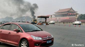 Vehicles travel along Chang'an Avenue as smoke raises in front of a portrait of late Chinese Chairman Mao Zedong at Tiananmen Square in Beijing October 28, 2013. Three people were killed and many injured on Monday, police said, when a car ploughed into pedestrians and caught fire in Beijing's Tiananmen Square, the site of 1989 pro-democracy protests bloodily suppressed by the government. REUTERS/Staff (CHINA - Tags: DISASTER POLITICS SOCIETY TPX IMAGES OF THE DAY) CHINA OUT. NO COMMERCIAL OR EDITORIAL SALES IN CHINA
