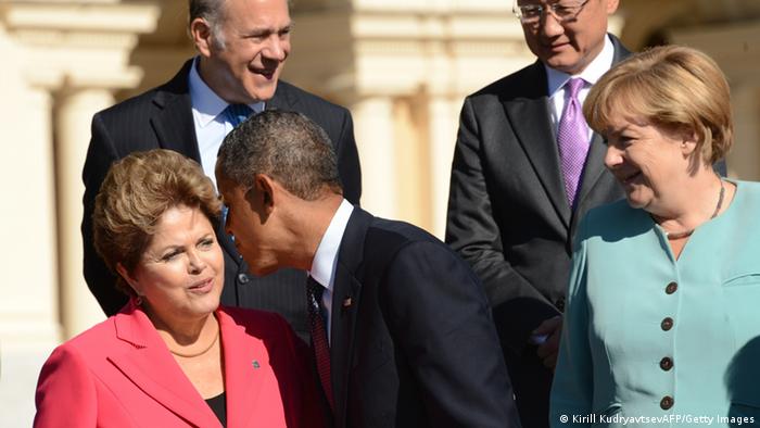 Brazils President Dilma Rousseff (L) is kissed by US President Barack Obama (C) as Germany's Chancellor Angela Merkel looks on (R) 