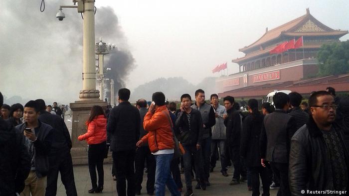 People walk along the sidewalk of Chang'an Avenue as smoke raises in front of the main entrance of the Forbidden City at Tiananmen Square in Beijing  People walk along the sidewalk of Chang'an Avenue as smoke raises in front of the main entrance of the Forbidden City at Tiananmen Square in Beijing October 28, 2013. Five people were killed and dozens injured on Monday, the government said, when a car ploughed into pedestrians and caught fire in Beijing's Tiananmen Square, the site of 1989 pro-democracy protests bloodily suppressed by the military. Chinese Foreign Ministry spokeswoman Hua Chunying, asked whether the government believed the incident was a terror attack, said she did not know the specifics of the case and declined further comment. REUTERS/Stringer (CHINA - Tags: DISASTER POLITICS) CHINA OUT. NO COMMERCIAL OR EDITORIAL SALES IN CHINA