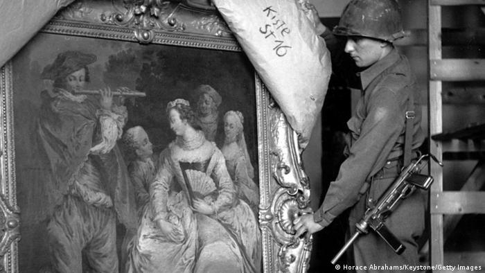 Black-and-white photo of a soldier pulling back a covering over a stolen Fragonard painting
Photo: Horace Abrahams/Keystone/Getty Images