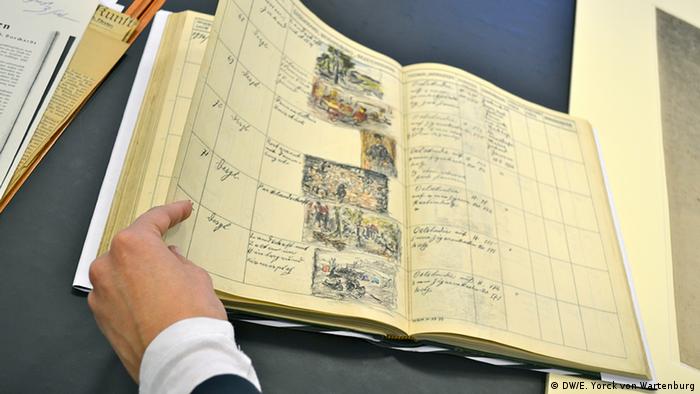 An open book with a hand in the corner, implying provenance research about the historical piece of art Photo: DW/Elisabeth Yorck von Wartenburg