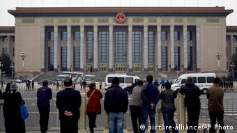 People watch as police officers check visitors in front of the Great Hall of the People during a gathering of the 205-member Central Committee's third annual plenum in Beijing, China Saturday, Nov. 9, 2013. Reform advocates are looking to China's leaders to launch a new era of change by giving entrepreneurs a bigger role in the state-dominated economy and farmers more control over land at a policymaking conference that opened Saturday. (AP Photo/Andy Wong)