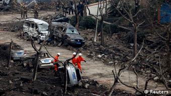 Rescuers search for survivors on a damaged road covered with debris after an explosion in a Sinopec Corp oil pipeline in Huangdao, Qingdao, Shandong Province November 23, 2013. As of Saturday morning, the accident has killed 44 people, with 136 injured, according to Xinhua News Agency. REUTERS/Aly Song (CHINA - Tags: DISASTER ENERGY TRANSPORT TPX IMAGES OF THE DAY)