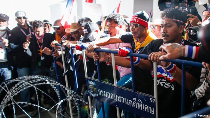 Anti-government protesters remove barricades and razor wire blocking a gate to the Department of Special Investigation (DSI) in Bangkok November 30, 2013. Police tightened security in Thailand's capital on Saturday as thousands of protesters rallied outside a state telecommunications group and vowed to occupy Prime Minister Yingluck Shinawatra's office to paralyse her administration. REUTERS/Athit Perawongmetha (THAILAND - Tags: POLITICS CIVIL UNREST)