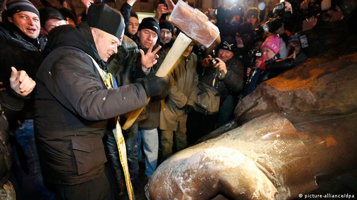 Ukrainian protesters hammer at a toppled statue of Lenin
(c) EPA/SERGEY