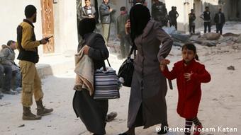 Women walk at a damaged site after an air strike in Aleppo (Photo: REUTERS/Hosam Katan)