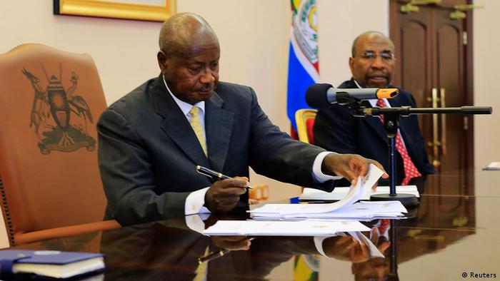 Uganda President Yoweri Museveni sgns a paper