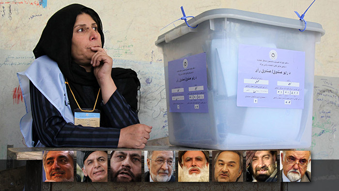 A woman sitting behind a ballot box