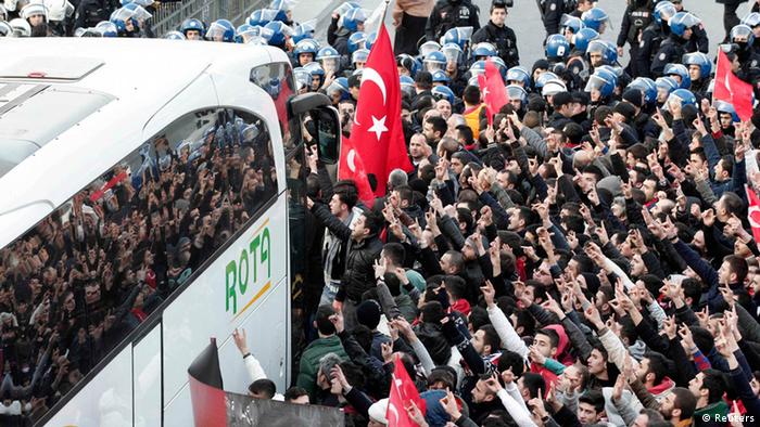 A bus is sorrounded by deomstrators with Turkish flags
(Foto: Osman Orsal/REUTERS)