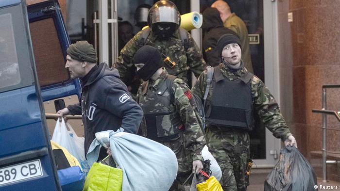 Members of the Ukrainian far-right radical group Right Sector leave their headquarters in Dnipro Hotel as police special forces stand guard in Kiev April 1, 2014. 