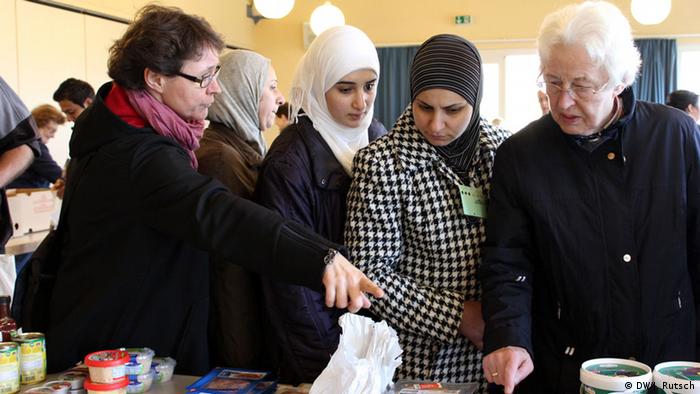 Andrea von Schmude helping Syrian women refugees at the food bank in Bornheim (Photo: Juli Rutsch, DW)