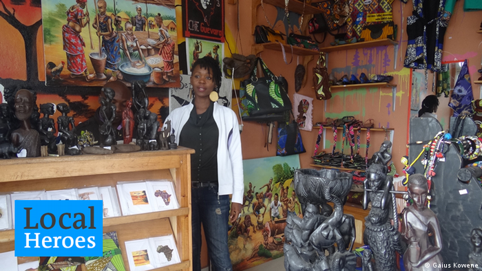 Mapendo Sumuni stands in the middle of her shop, surrounded by carvings and paintings. Photo: Gaius Kowene