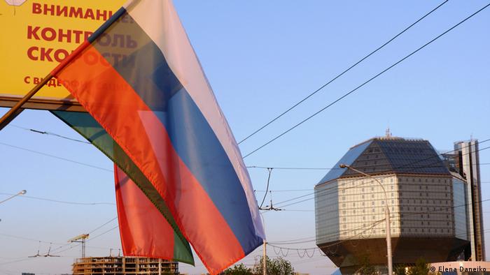 Российский флаг на фоне национального белорусского флага на улице в Минске 