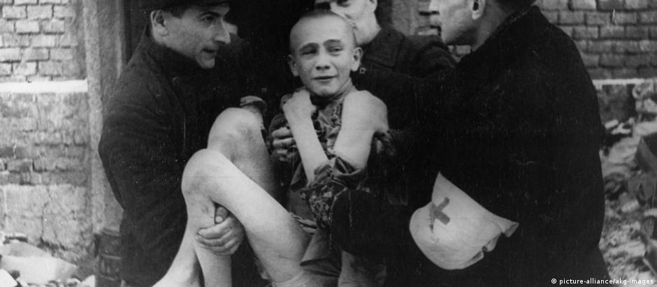 Soldados soviéticos retiram um jovem de 15 anos do campo de concentração de Auschwitz, em 1945