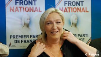 National Front leader Marine le Pen in front of election posters