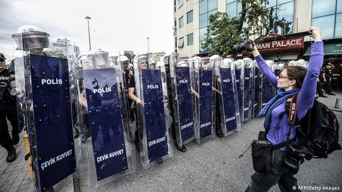 Turkish riot police officers standing in line as they block access to Taksim Square