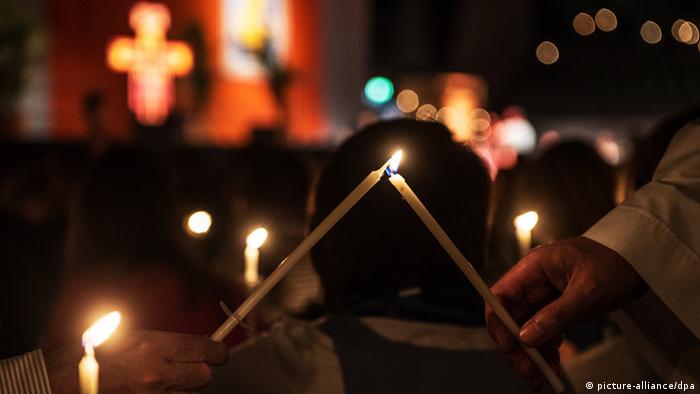 Верующие зажигают свечи на службе в церкве