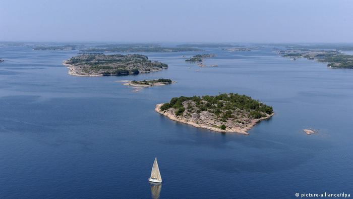 Vor zwei Inseln schwimmt ein Segelboot. (Foto: Picture-alliance/dpa)