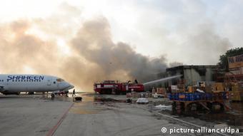 Пожарные тушат здание терминала, атакованного боевиками