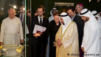 Ulrike al-Khamis showing the exhibition to Sheikh Sultan III bin Mohammed al-Qasimi, Emir of Sharjah, and the Director of the Ethnological Museum in the Vatican, Father Nicola Mapelli, Photo: sharjahmuseum.ae