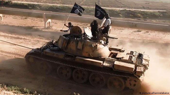 A tank flying the ISIS black-and-white flag in a desert setting
