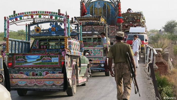 Un soldado camina camiones últimos se dirigían a Waziristán del Norte para llevar a los refugiados que huían de la ofensiva militar contra los militantes paquistaníes, en las afueras de Bannu, en la provincia paquistaní de Khyber Pakhtunkhwa, 19 de junio 2014 (Foto: REUTERS / Zahid Mohammad)