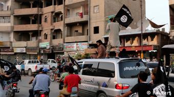 Raia wakipeperusha bendera za IS katika mji wa Raqqa nchini Syria.