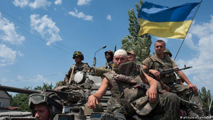  Ukrainian government soldiers drive atop an armored personal carrier with a Ukrainian national flag, outside the city of Siversk, Donetsk region, eastern Ukraine, Saturday July 12, 2014. (AP Photo/Evgeniy Maloletka) 