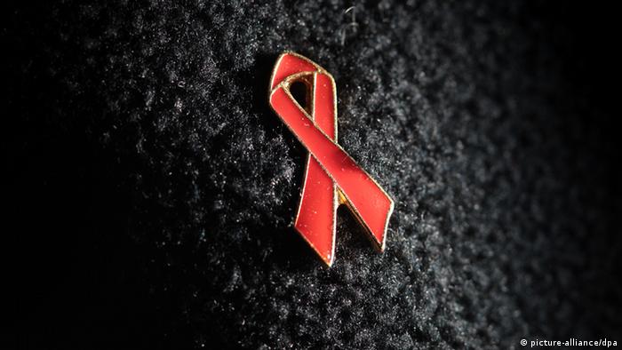 Symbolbild AIDS Schleife auf schwarzem Hintergrund